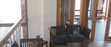 A room with wooden furniture, a sign for meditation and yoga, and a view through a window.