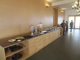 Disposição de buffet com diversos alimentos e utensílios de servir.