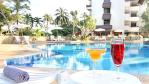 A poolside view with lounge chairs and a table with two drinks. - Rayong Chalet Resort (Klaeng)