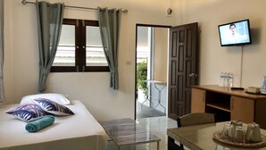 A hotel room with a bed, a TV, a small table with a tray, and a view of the outside. - Samui Zenity Hotel (Koh Samui)