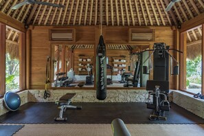 A gym with exercise equipment, a punching bag, and a mirror.