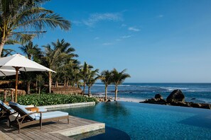 Outdoor pool, an infinity pool, pool umbrellas, pool loungers