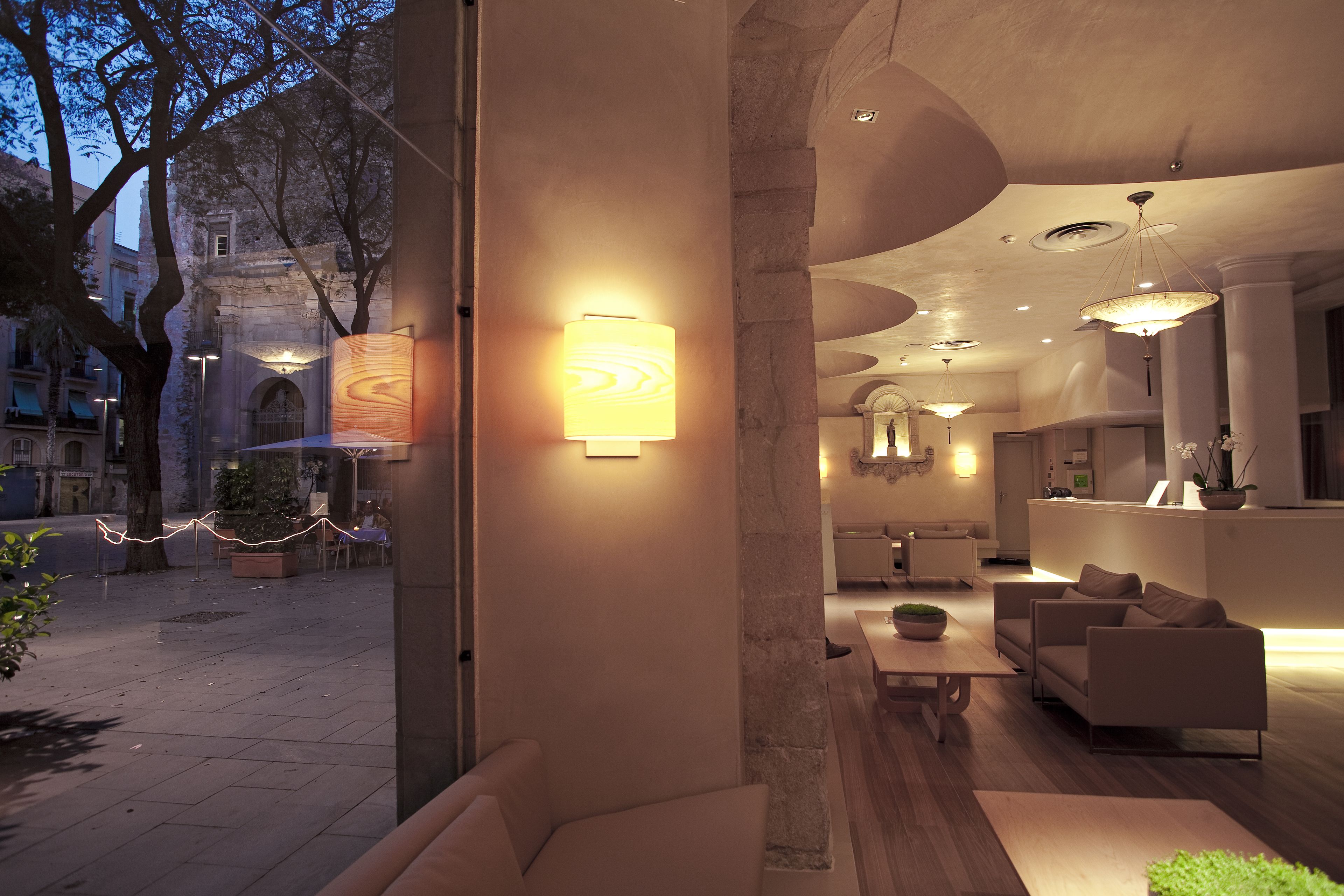 Un espace intérieur comprenant un coin salon, un comptoir d’accueil et une vue sur l’extérieur.