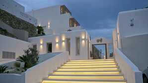 Un edificio moderno y blanco con una escalera que lleva a una puerta.