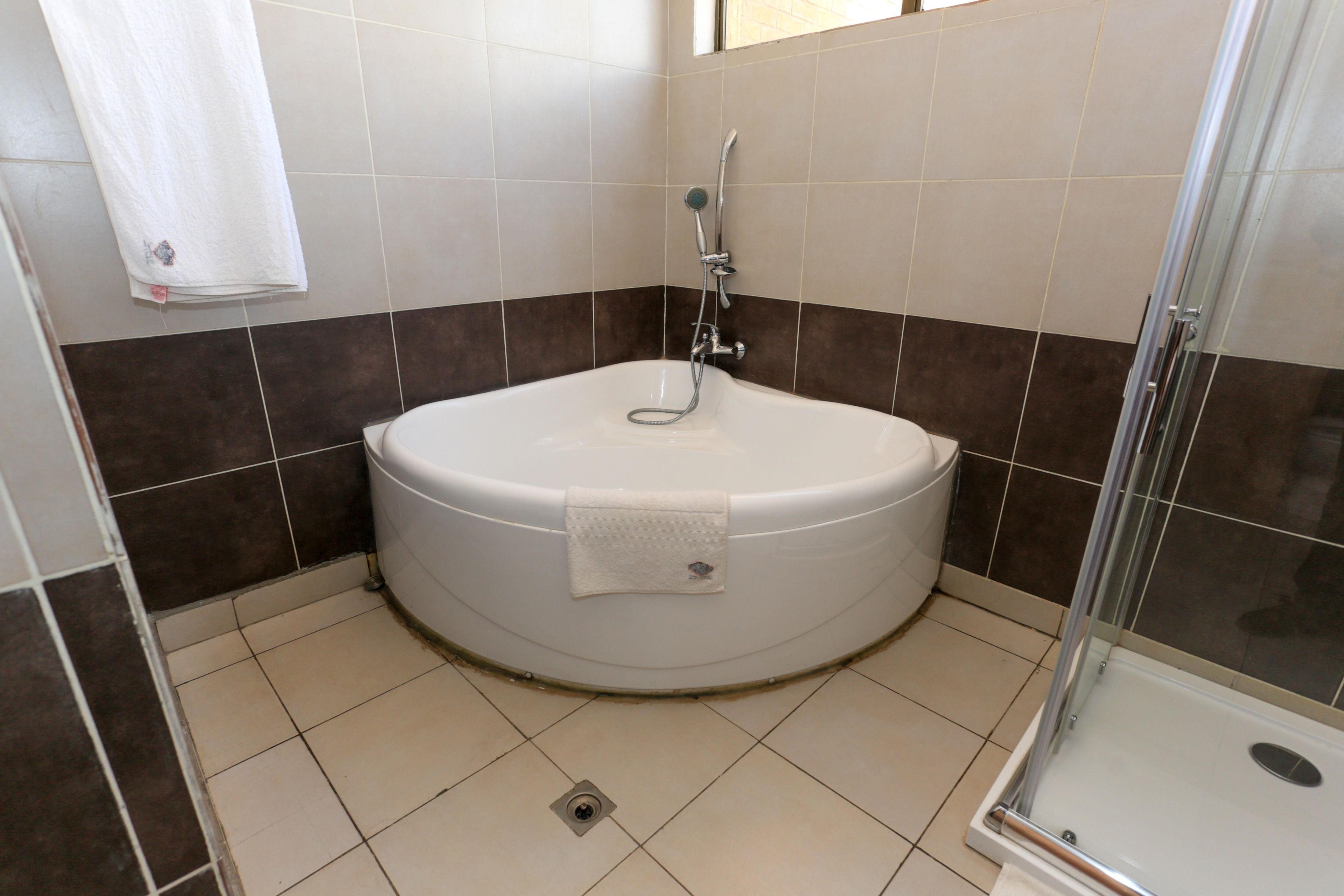 A bathroom with a bathtub, a shower, and a glass-enclosed shower area.