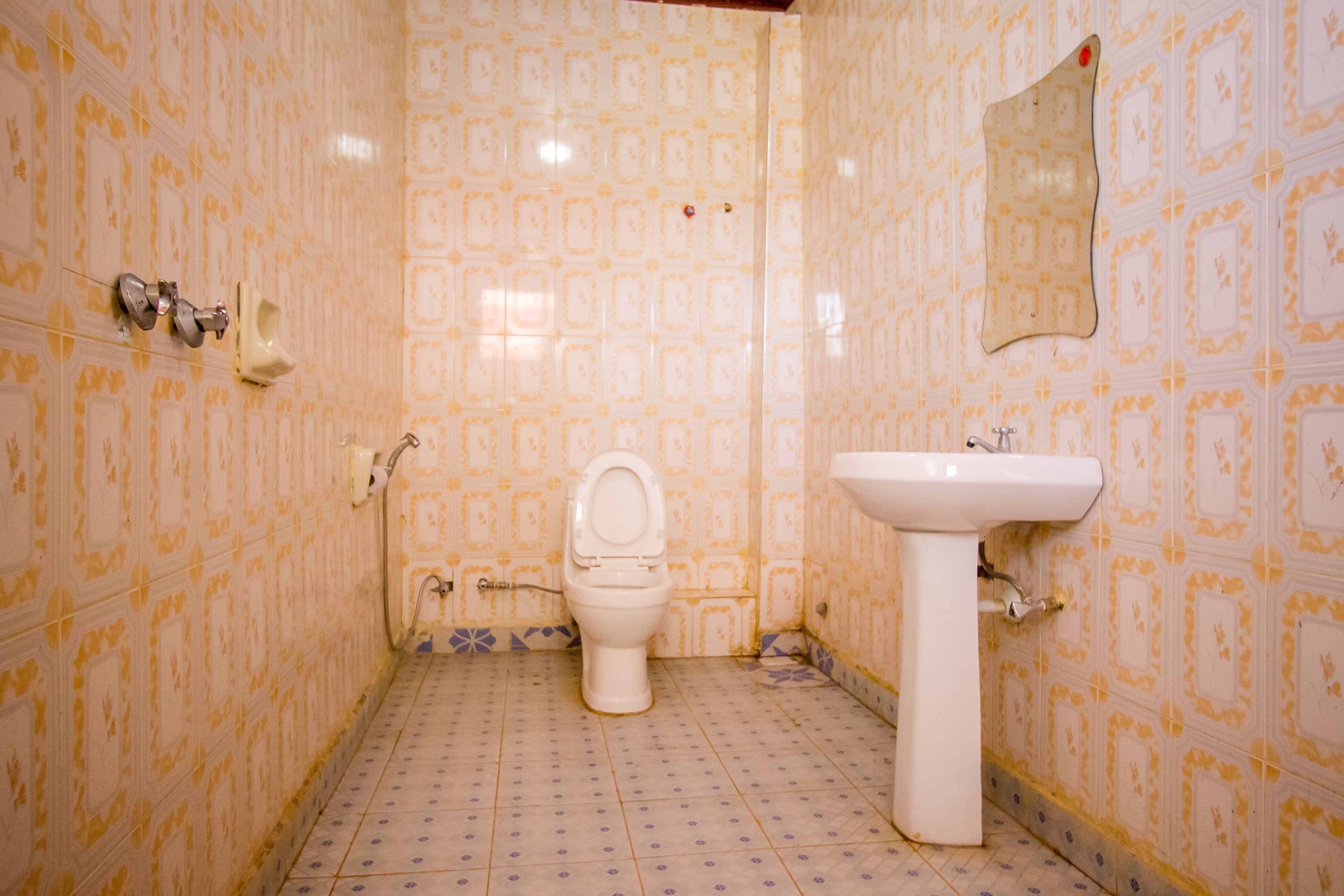 Un baño con paredes de diseño, un inodoro y un lavabo.