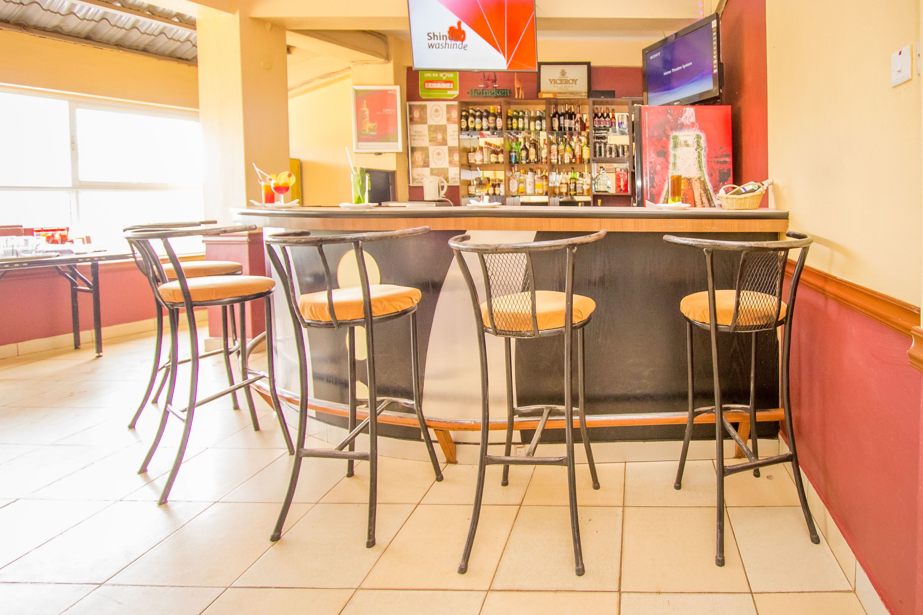 A bar area with four stools and a bar counter.