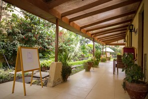 A covered outdoor area with a whiteboard, potted plants, and a tiled floor. - Eseriani The Hotel (Naivasha)