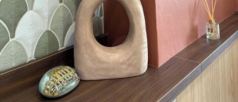 A decorative vase with pampas grass on a wooden counter.