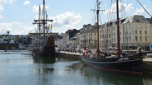 A harbor with two large sailing ships docked, surrounded by historic buildings and a crowd of people. - Hôtel Ambassadeur (Cherbourg-en-Cotentin)