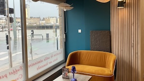 A modern interior with a sofa, table, and hanging lamps. - Hôtel Ambassadeur (Cherbourg-en-Cotentin)
