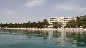 Un hotel costero con varios pisos, ubicación frente a la playa y vistas al mar.
