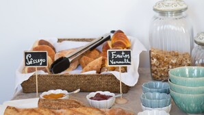 Un bufé de desayuno con panes, bollería y frutas.