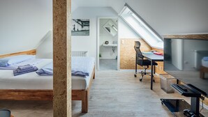 A modern bedroom with a lofted sleeping area, a desk, and a television. - Aparthotel Pumpengasse (Wolfsburg)