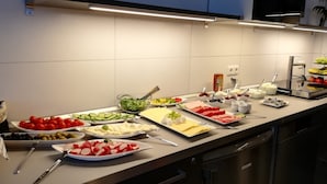 A buffet setup with various food items and utensils. - Aparthotel Pumpengasse (Wolfsburg)