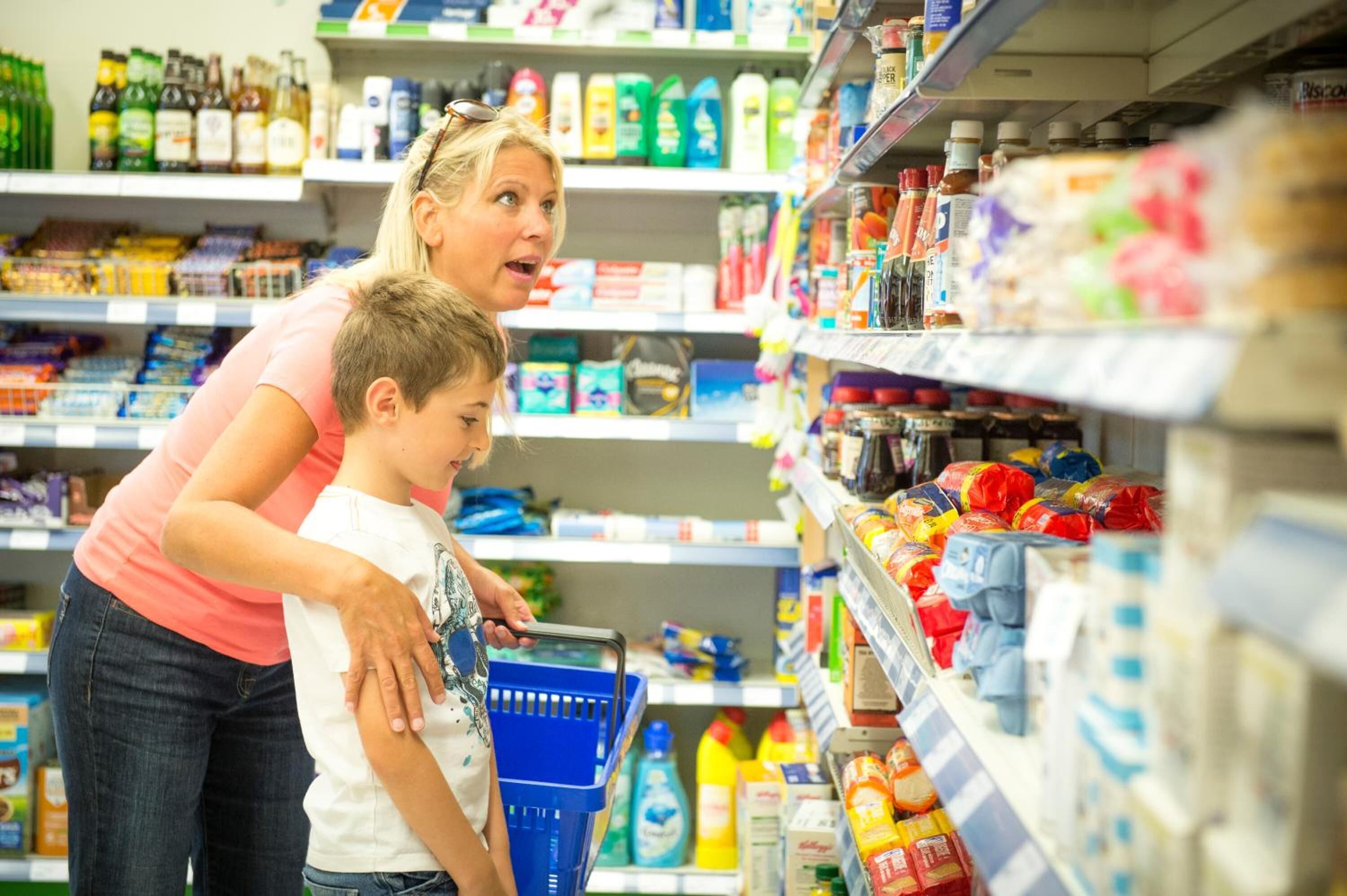 A woman and a child shopping in a grocery store aisle.