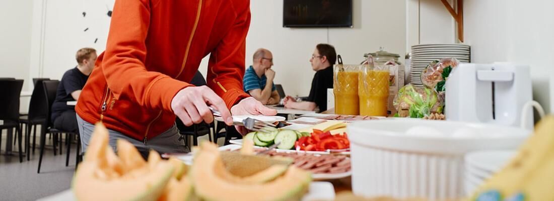 Une personne qui sert des plats et des boissons à un buffet.