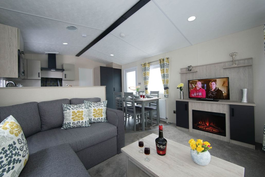 A modern living room with a sofa, coffee table, and a fireplace.