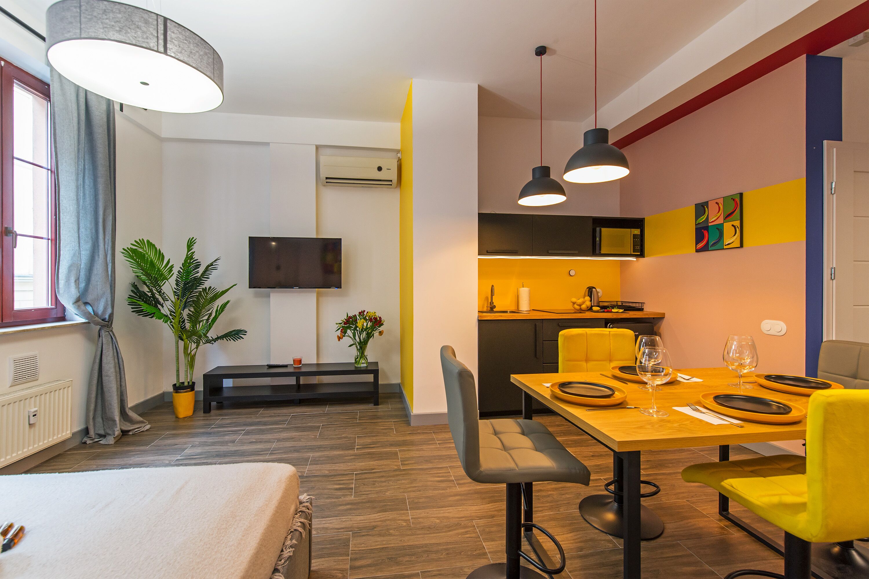 A modern apartment with a dining area, kitchen, and living space.