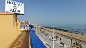 Un hotel llamado "HOSTAL ALBA" con vistas a la playa y al océano.