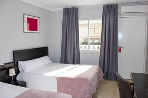 A hotel room with a bed, bedside table, and a window with curtains. - Hostal Alba (Torrevieja)