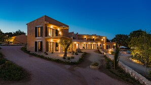 A modern two-story house with a driveway leading to the entrance, surrounded by landscaped gardens and trees. - Agroturismo Ses Vistes (Porreres)