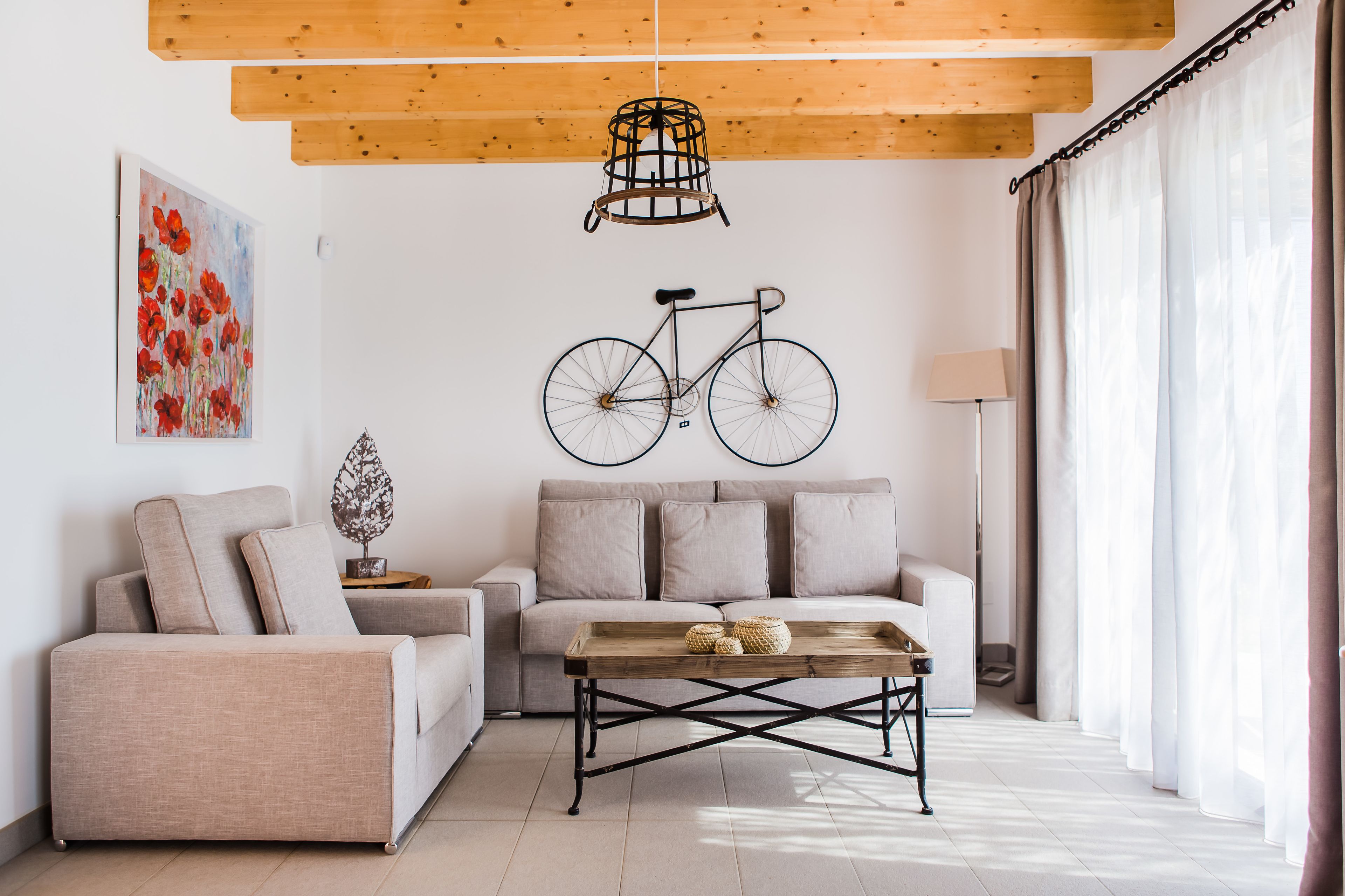 Una sala moderna con un sofá, una mesa de centro y una obra de arte de bicicleta en la pared.