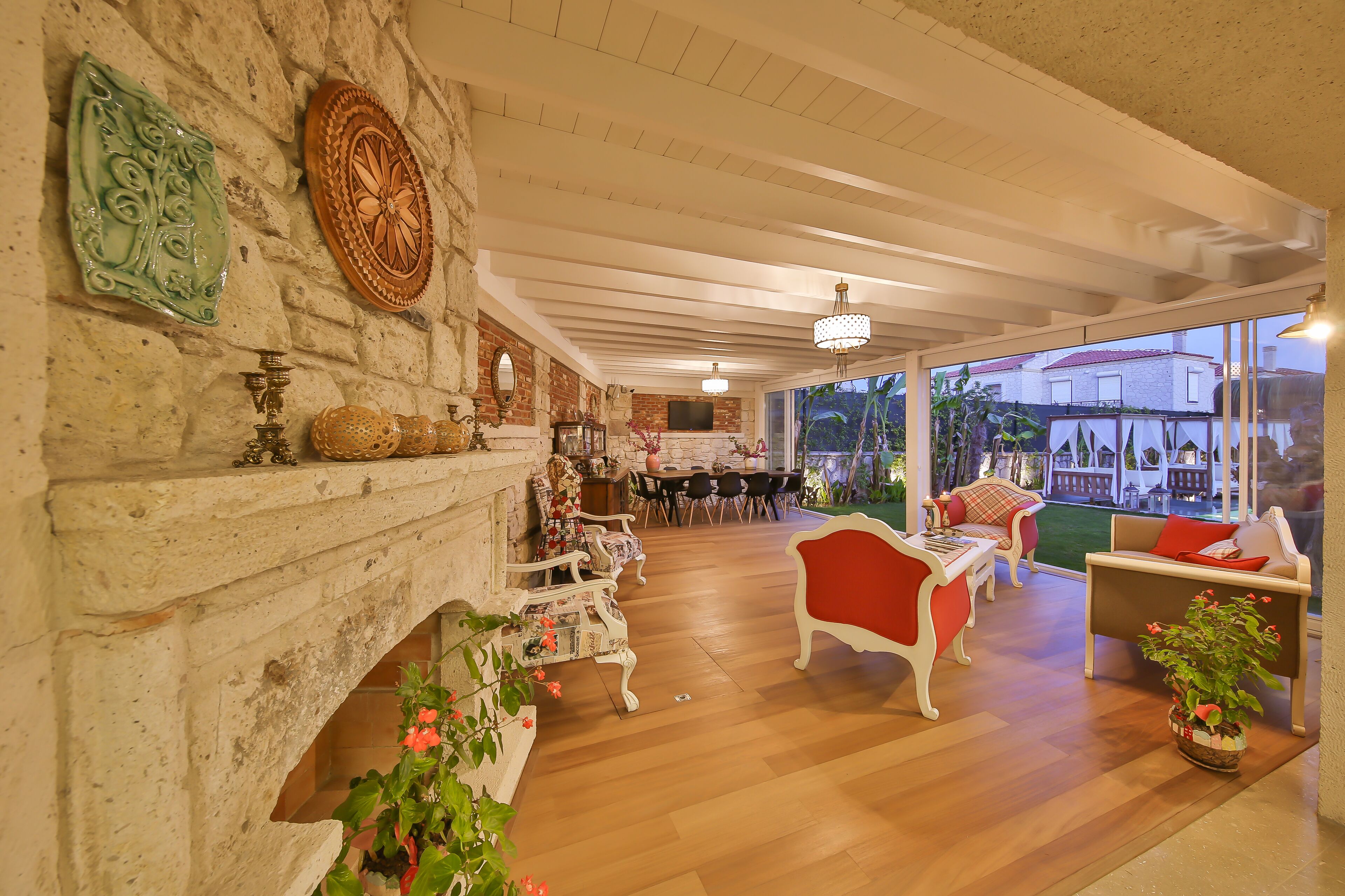 A cozy interior with a fireplace, wooden flooring, and a view of the outdoors.