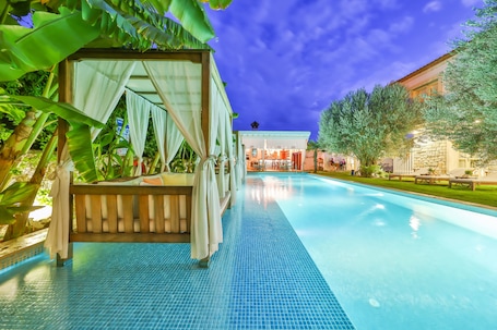 Una piscina al aire libre, camas de piscina gratis, sombrillas