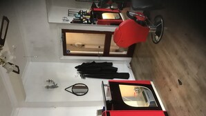 A room with a red bicycle, a mirror, a black umbrella, and a record on the wall. - South Dene Hotel (Bridlington)