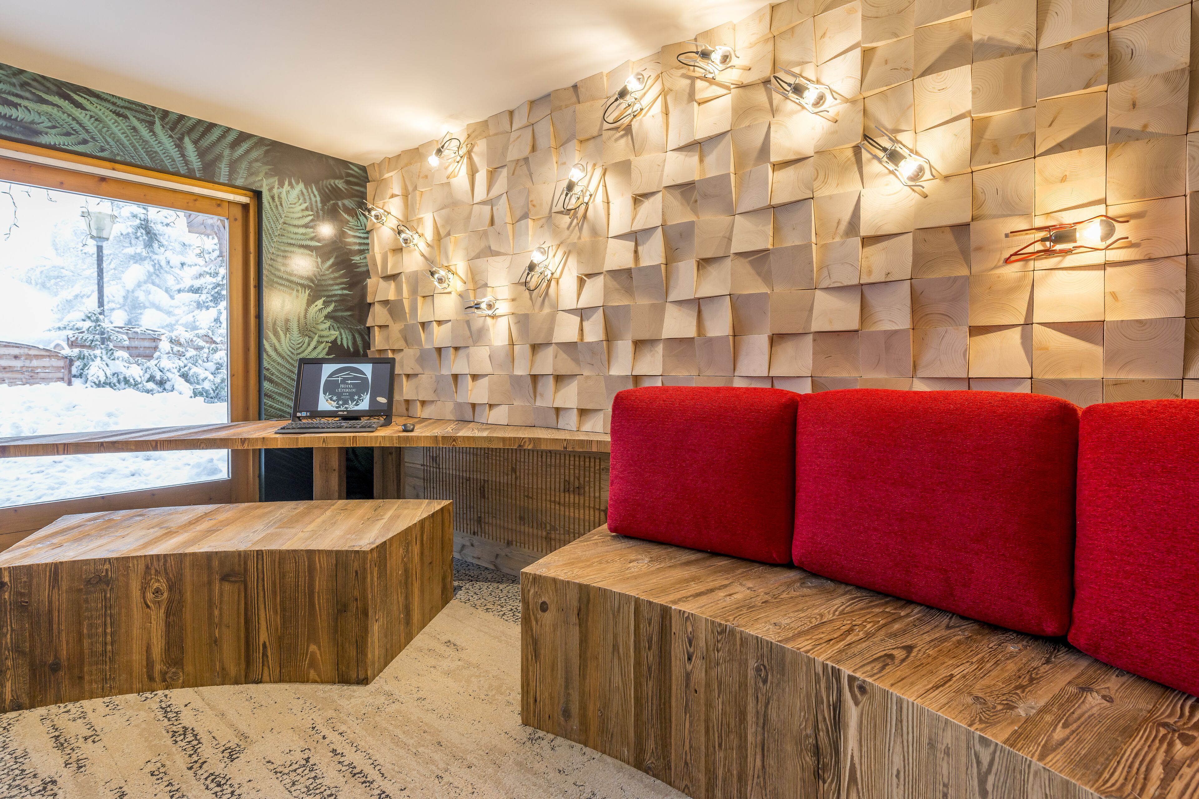 A modern interior with a wooden wall, a red sofa, and a wooden bench.