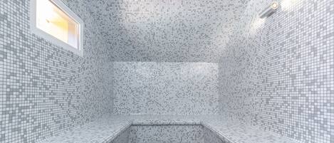 A tiled room with benches and a window.