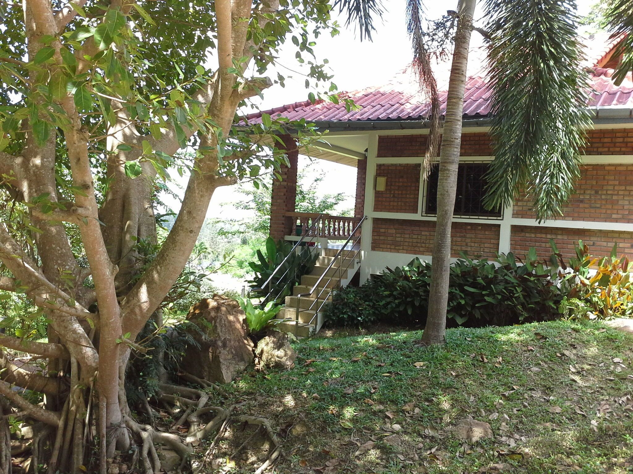 A house with a red roof, a porch, and a staircase leading to the entrance.