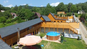 Una cabaña de madera con piscina, terraza y un patio cubierto.