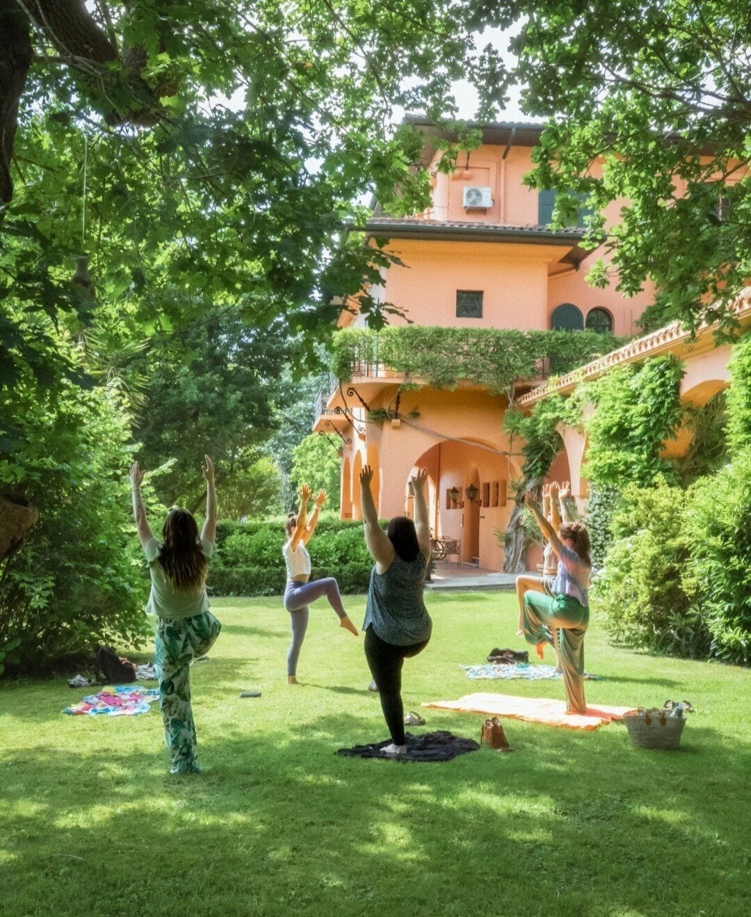 A courtyard with a building in the background, surrounded by greenery.