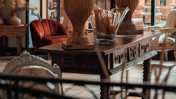 Un interior acogedor con una mesa de madera, dos jarrones decorativos y una silla roja.