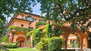 Un patio con un edificio que tiene arcos y un candelabro colgante.