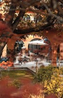 Un espacio al aire libre con mesas y sillas, rodeado de arcos y árboles.