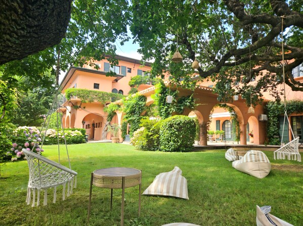 A courtyard with a hanging chair, a small round table, and a hammock. - Hotel Chantaco Golf & Wellness (Saint-Jean-de-Luz)
