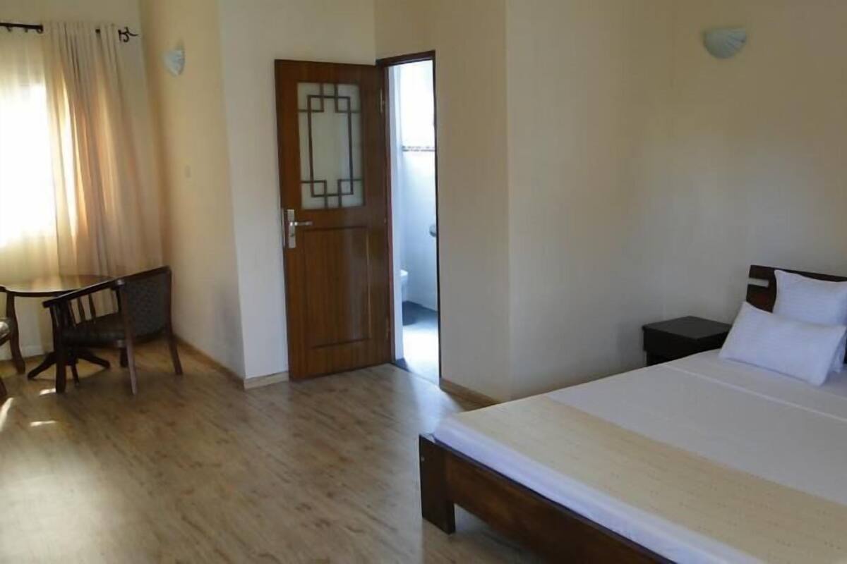 Una habitación de hotel con una cama de madera, un escritorio y una silla.