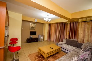 Apartamento Deluxe, 2 habitaciones | Zona de estar | Una televisión de pantalla plana