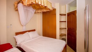 Une chambre à coucher avec un lit, une armoire et un miroir.