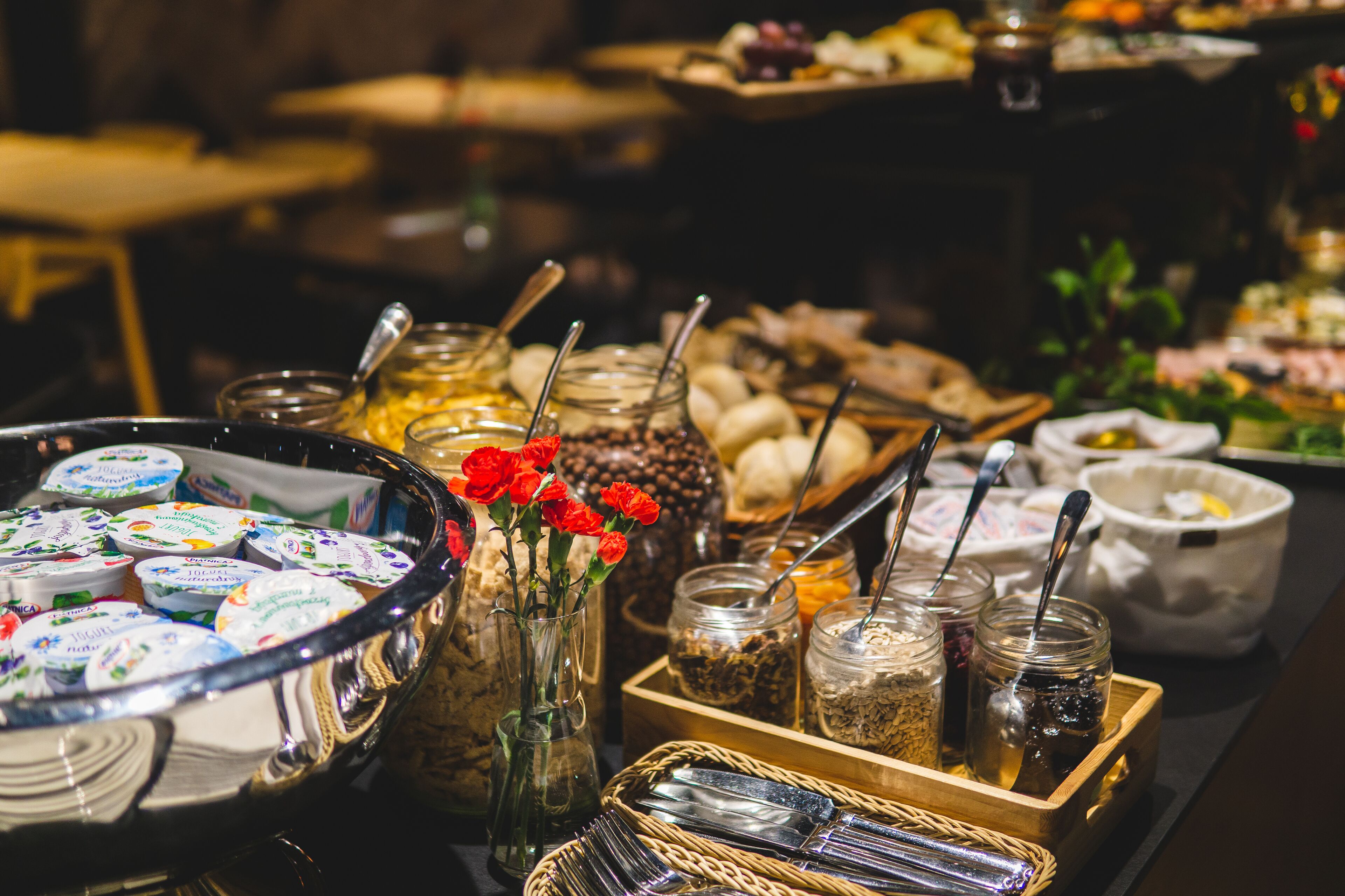 A buffet table with various food items and utensils.