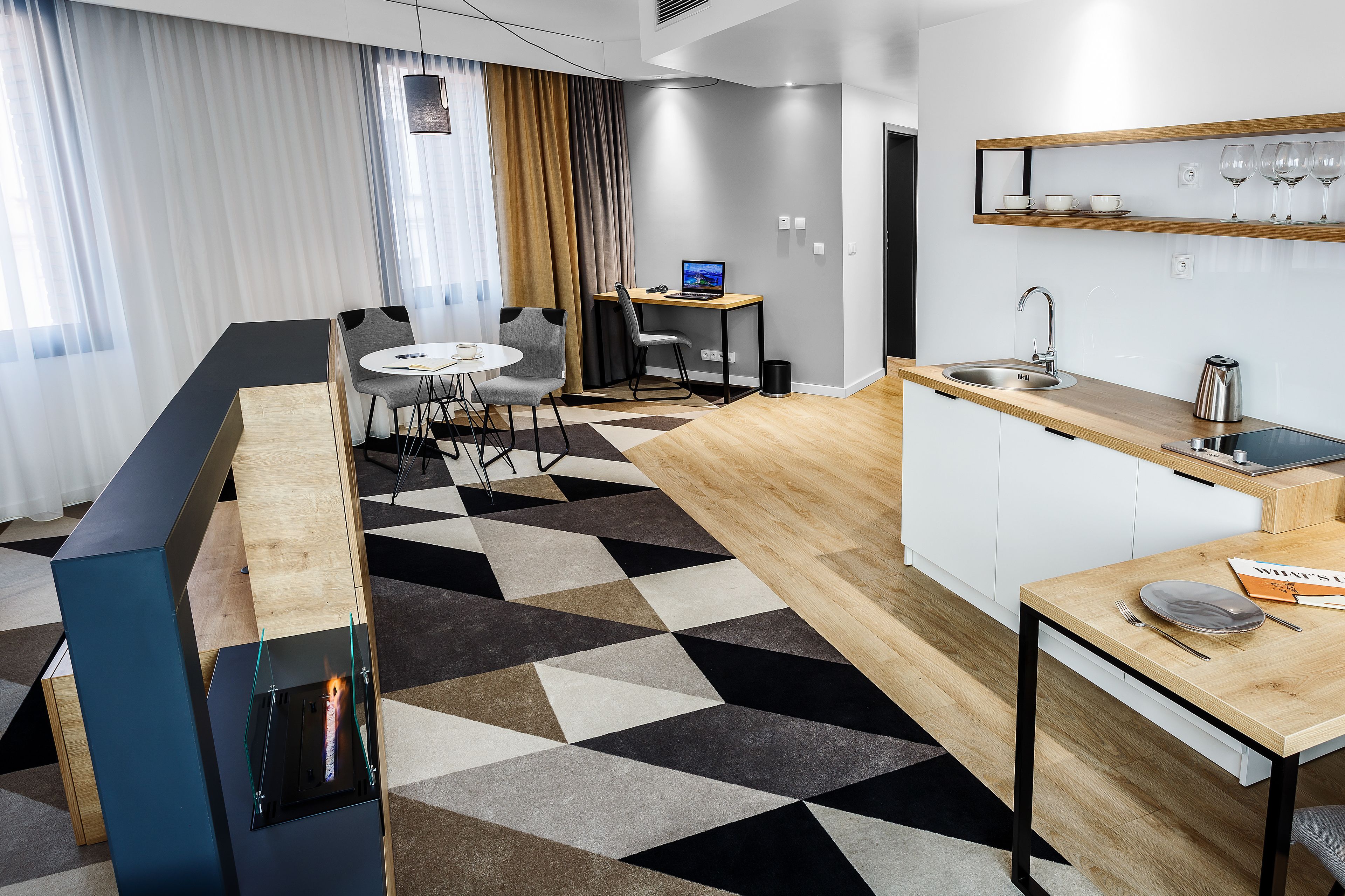 A modern kitchen with a wooden countertop, a sink, and a dining area with a table and chairs.