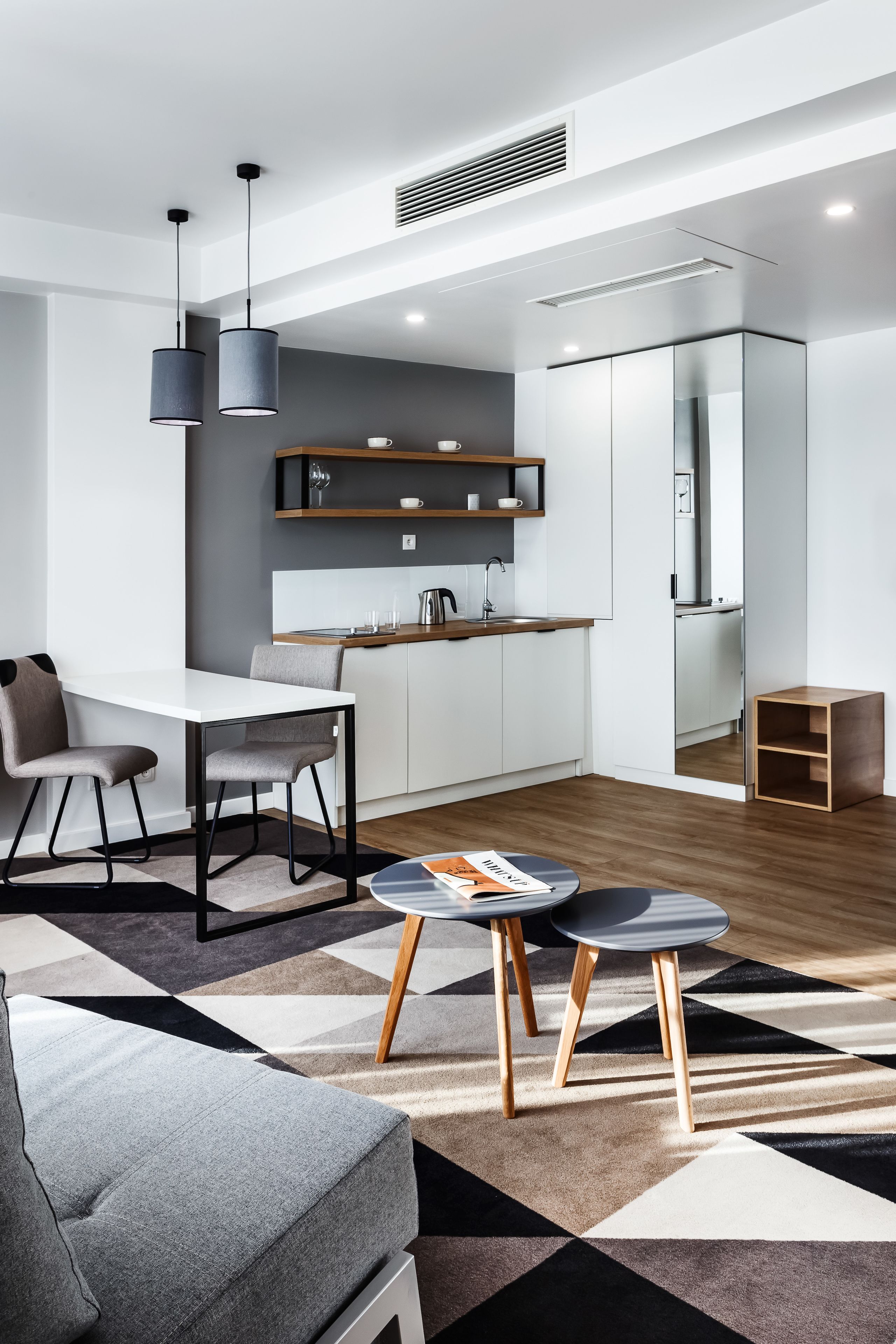 Una sala de estar moderna con comedor, cocina y un pequeño armario de madera.