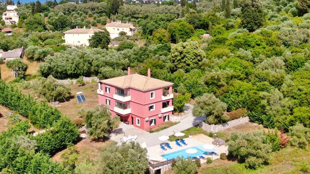 A pink villa with a pool, surrounded by lush greenery and a view of the sea. - Villa Jazz Rock (Corfu)
