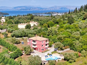 A pink villa with a pool, surrounded by lush greenery and a view of the sea. - Villa Jazz Rock (Corfu)