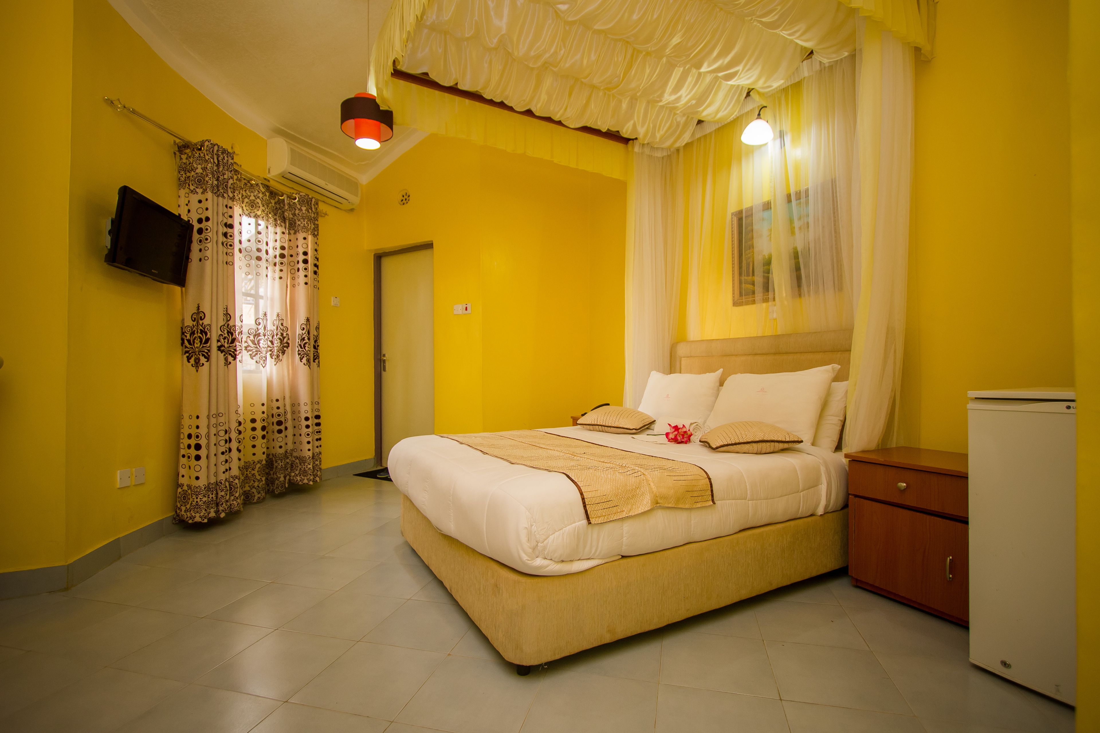 Un dormitorio con cama, mesita de noche, televisor y armario.