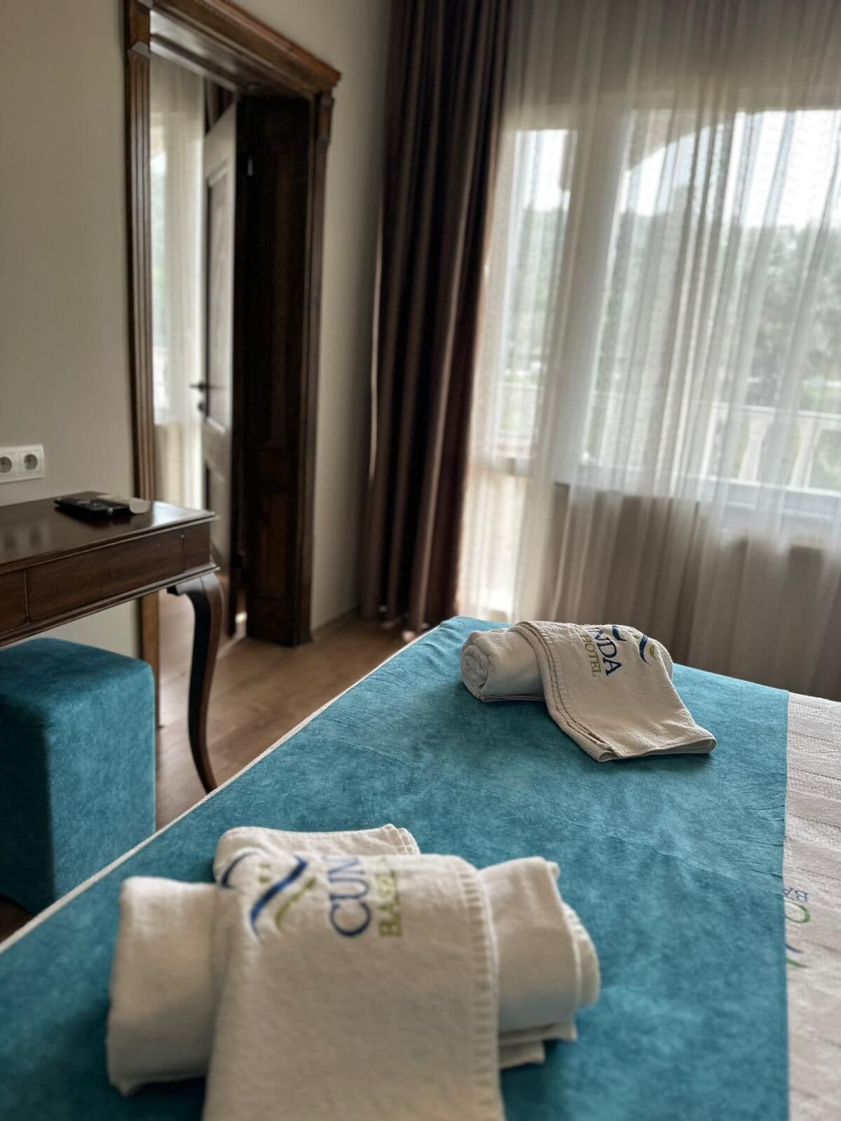 A hotel room with a bed, a desk, and a mirror.