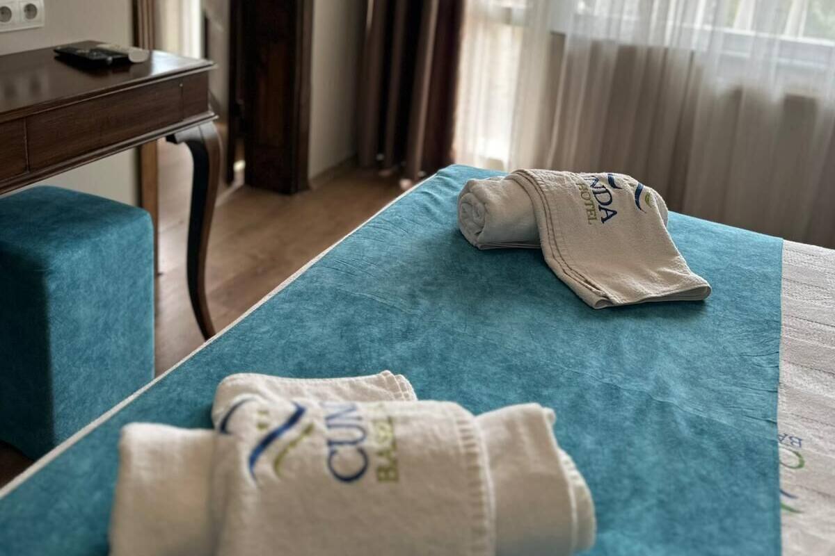 A hotel room with a bed, a desk, and a mirror.